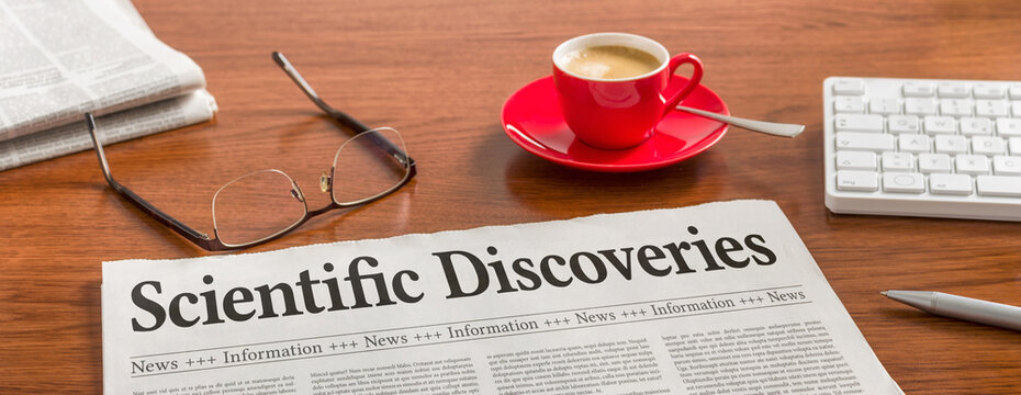 A newspaper on a wooden desk - Scientific Discoveries