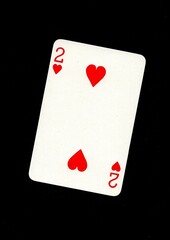 Obraz premium A playing card in the suit of hearts isolated on a black background.