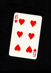 A playing card in the suit of hearts isolated on a black background.