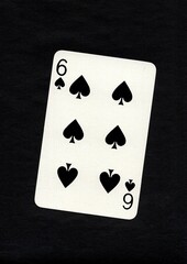 Playing card in the suit of spades isolated on a black background.