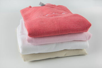 sweatshirts in different colors and designs stacked on top of each other