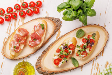 Tasty antipasto toasts featuring classic caprese with mozzarella and tomatoes, and savory prosciutto with herbs