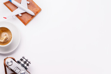 Travel-themed flat lay with toy airplane, camera, and coffee