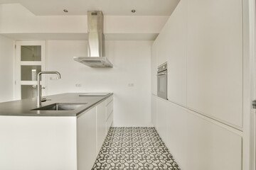 A sleek and modern kitchen featuring white cabinetry, a minimalist layout, and patterned tile flooring, ideal for contemporary home aesthetics.
