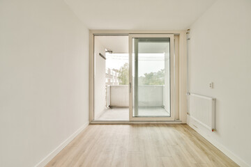 A bright, airy interior space featuring a sliding glass door leading to a balcony, showcasing a seamless connection between indoor and outdoor environments.