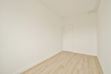 A spacious empty room featuring light wood flooring and white walls, providing a clean, minimalist aesthetic perfect for various uses.