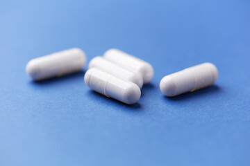 Arginine capsules on bright wooden background. Soft focus. Close up. Copy space.	