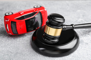 Motor vehicle accident law. Gavel and car model on grey background