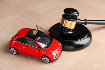 Motor vehicle accident law. Gavel and car model on wooden background, closeup