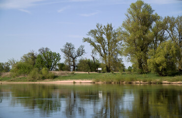 The river with its calm waters, and on the bank you can see a sign with numbers,