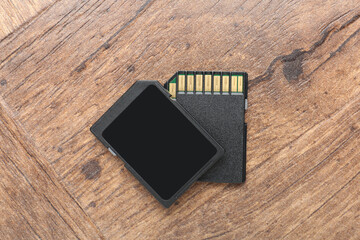 Two SD memory cards on wooden table, top view