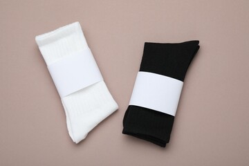 Pairs of stylish socks on beige background, top view