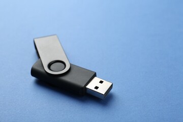 One flash drive on blue background, closeup. Space for text