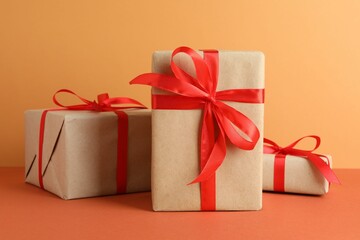 Many gift boxes wrapped in kraft paper on orange table