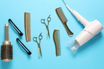 Different hairstyling tools on light blue background, flat lay