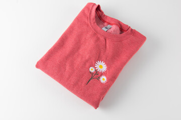 red and yellow cloth, a red sweater with a pretty flower pattern right above the heart.
