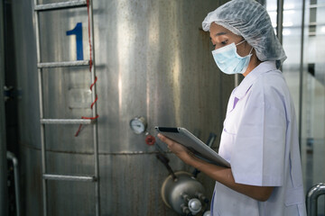 A food factory researcher inspecting canned food conveyor belt machine. Worker checking on quality...