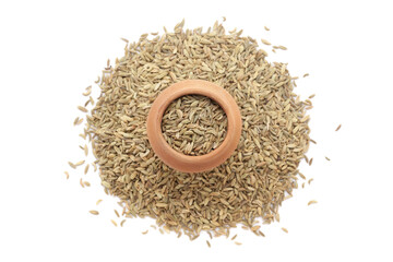 A mud pot filled with organic Fennel Seeds (Foeniculum vulgare), Badi saunf, is placed on a heap of Fennel Seeds, isolated on a white background.