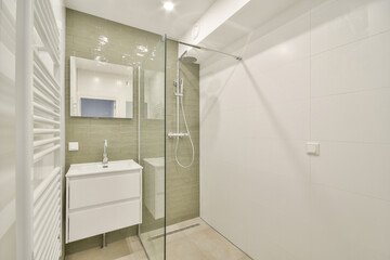 Sleek and contemporary bathroom featuring a glass shower and stylish sink with modern tiles and lighting accents, creating a clean and inviting space.
