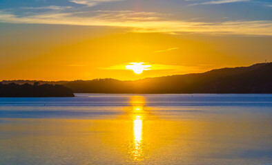 Fototapeta premium Sunrise with high cloud, boats and reflections over the water