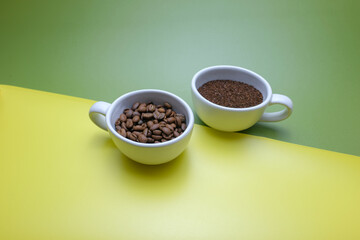 Two Coffee Cup Filled with Ground Coffee and Beans on Colorful Background
