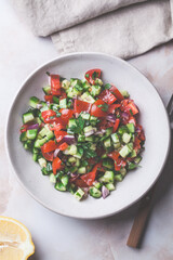 Vegetable salad with tomatoes, cucumbers, onions and parsley.