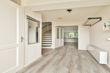 A well-lit interior showcasing elegant flooring and a staircase, blending modern design with simplicity for an inviting atmosphere.