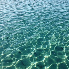 Crystal clear turquoise water with sun reflections creating abstract patterns on the surface. Calm and serene aquatic scene. High resolution