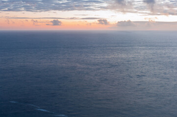 Obraz premium The ocean is calm and the sky is a beautiful orange color