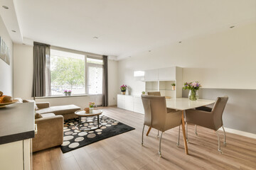 A contemporary living space featuring minimal furniture, large windows, and natural light, focused on simplicity and comfort in the layout.