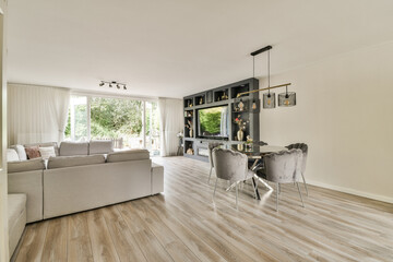 A stylish and airy living room featuring contemporary furniture, large windows allowing natural light, and a cozy atmosphere perfect for relaxation.