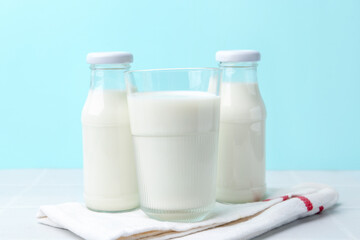 Fresh milk on white table against light blue background