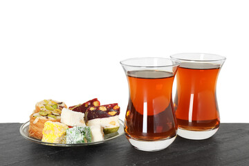 Tasty Turkish tea and delight on table against white background