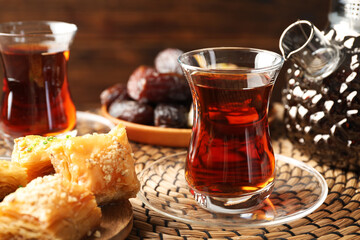 Tasty Turkish tea served with sweets on table, closeup