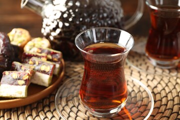 Tasty Turkish tea served with sweets on table, closeup