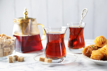 Tasty Turkish tea served with sweets on white marble table