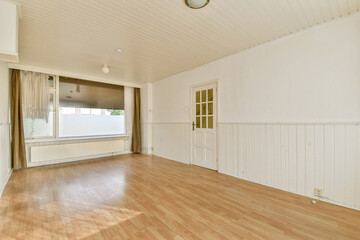 A spacious, minimalistic interior featuring wooden flooring and plain white walls, creating a serene and open atmosphere ideal for decoration.