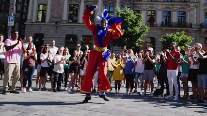 Stilt walker wearing a colorful costume performs a lively dance routine in front of an appreciative crowd in riga, latvia, captivating onlookers with impressive balance and rhythmic movements