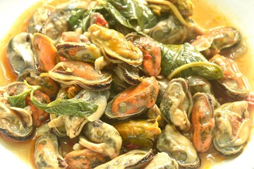 spicy stir fried mussel with chilin and basil leaf in curry sauce on plate 
