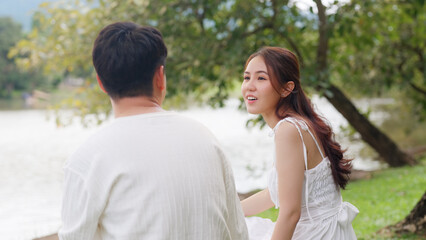 Young adult asia people happy lover flirt at public nature park falling in love desire kiss hug beloved care trust. Sweet asian lovers tender face to face man woman smile relax warm time date day.
