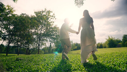 Back rear view young lover asia people happy smile trust hold hand enjoy relax walk way forward to...