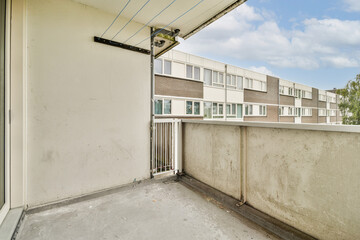 A spacious balcony showcasing modern architectural design, with clean lines and a view of neighboring structures under a clear sky.