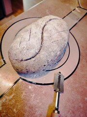 unbaked artisanal sourdough bread freshly scored with a razor before baking on silicone mat
