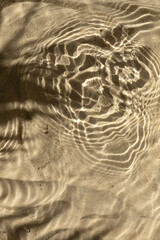Water texture with shadows on sea beach sand