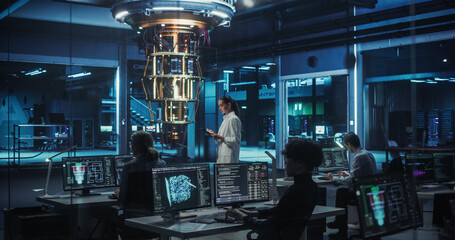 Portrait of a Female Researcher Standing Before a Powerful Quantum Computer, Using a Tablet...