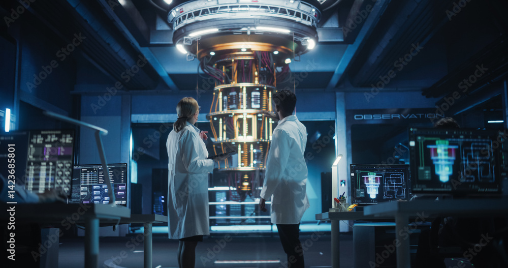 Poster portrait of engineers standing in a research center, using a tablet next to a powerful quantum proce