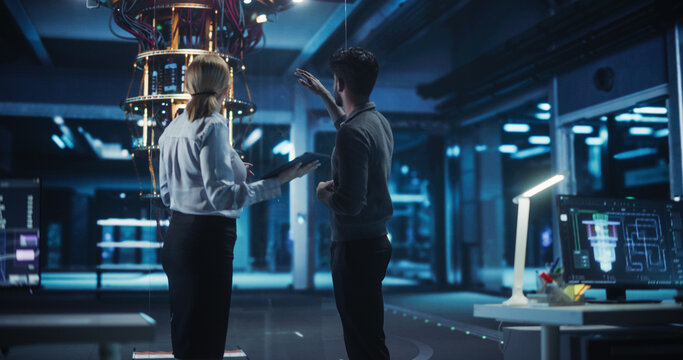 Portrait of Engineers Standing in a Research Center, Using a Tablet Next to a Powerful Quantum Processor. Diverse Male and Female Developers Working Together on Solving Artificial Intelligence