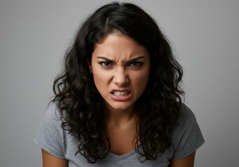 Furious woman expressing intense emotion with fierce gaze in gray shirt