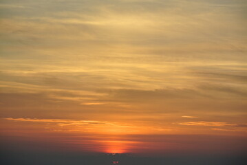 Stunning Sunset with Golden and Orange Hues, Wispy Clouds, and a Distant Horizon – A Tranquil and Scenic Display of Nature’s Beauty