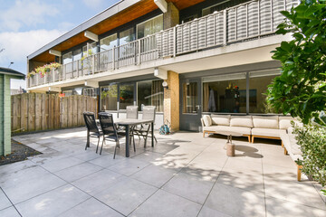 This image features a stylish outdoor patio area showcasing modern furniture, greenery, and a well-maintained atmosphere perfect for relaxation and gatherings.